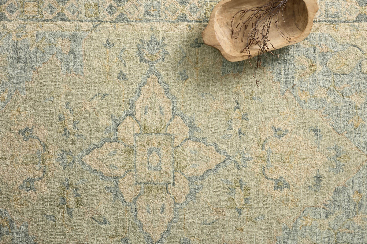 Seafoam green textured hooked rug with geometric medallion and distressed motifs