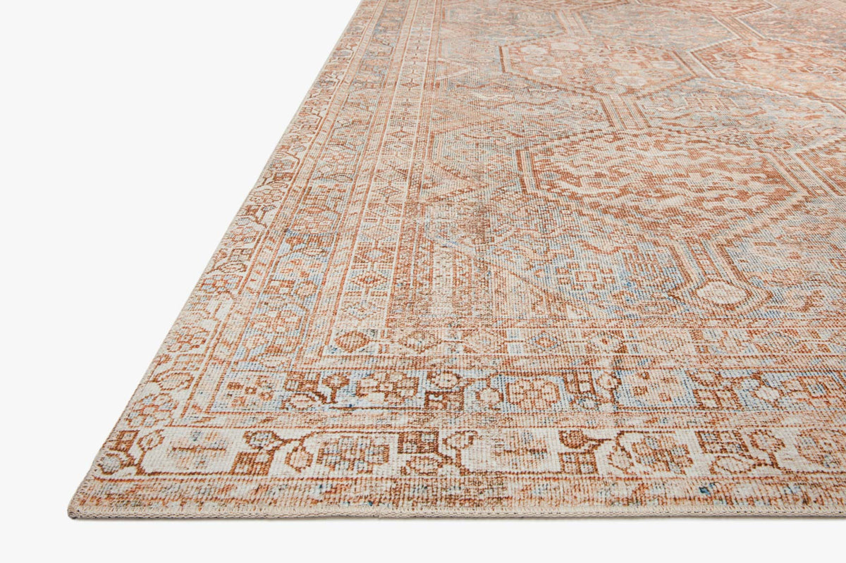 Close-up of tangerine and mist rug weave with detailed geometric pattern and border trim
