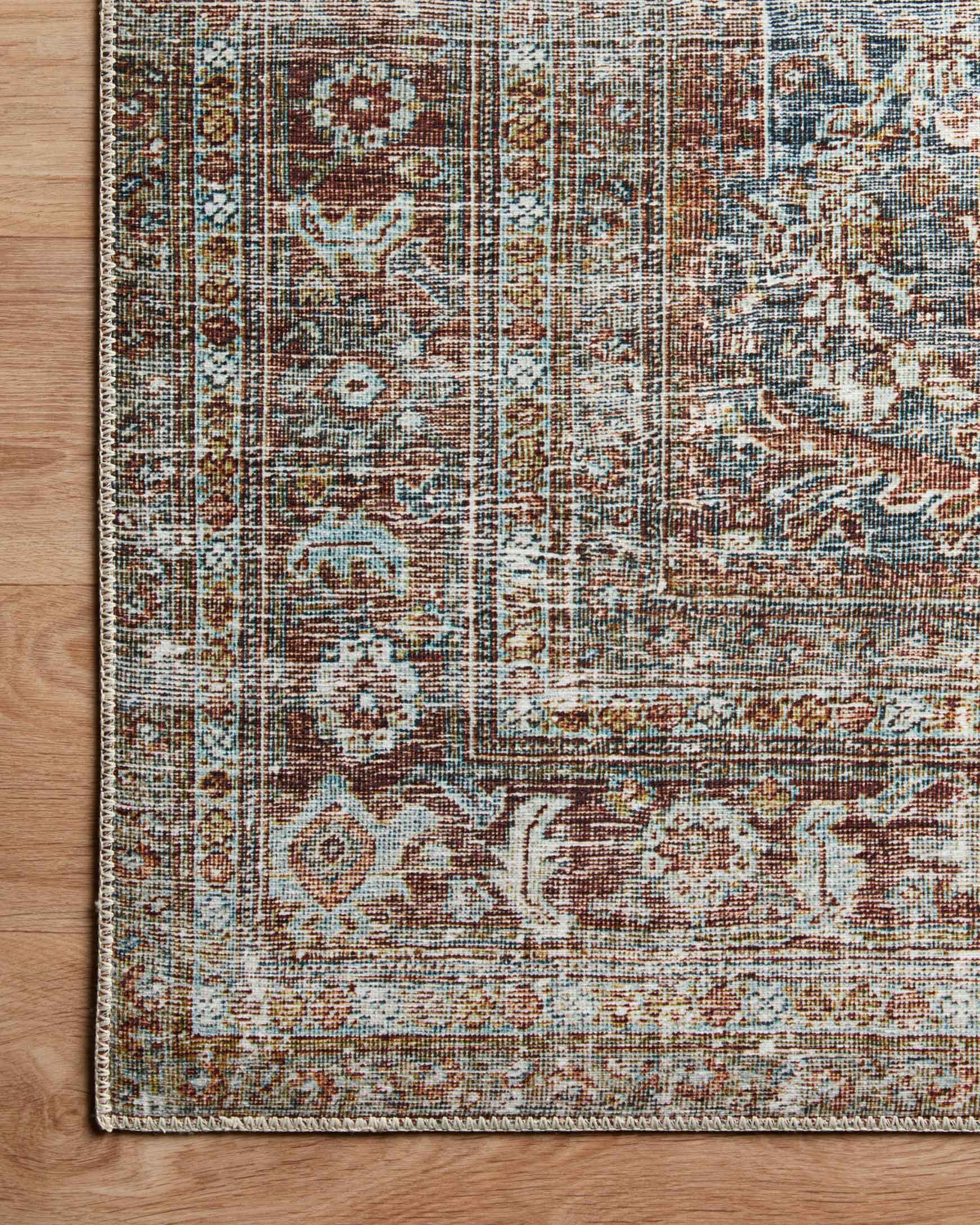 Corner detail of distressed patterned rug in lagoon blue with rust and tan elements