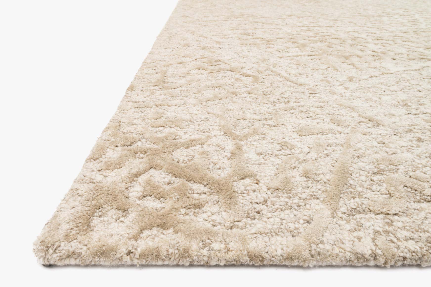 Hand-tufted rug corner with plush high-pile texture in ivory and beige