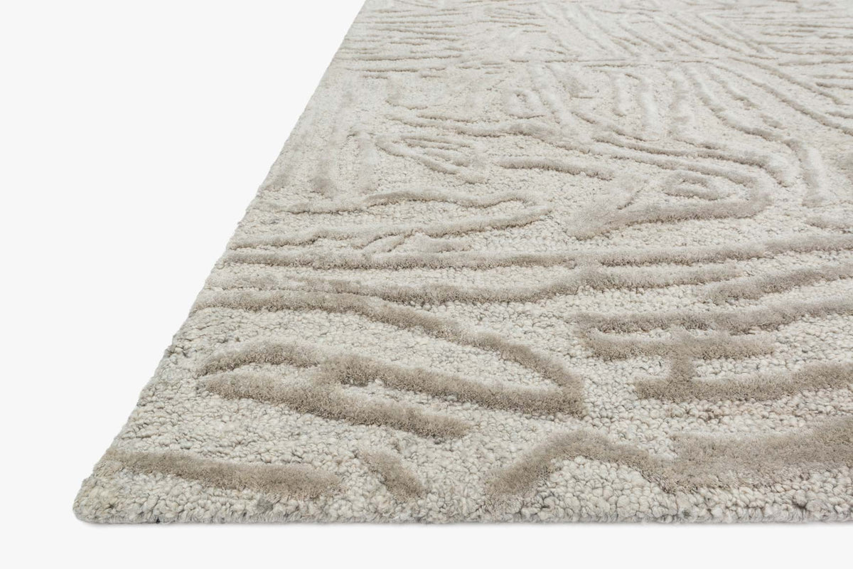 Silver hand-tufted rug corner with thick raised loops and abstract motif