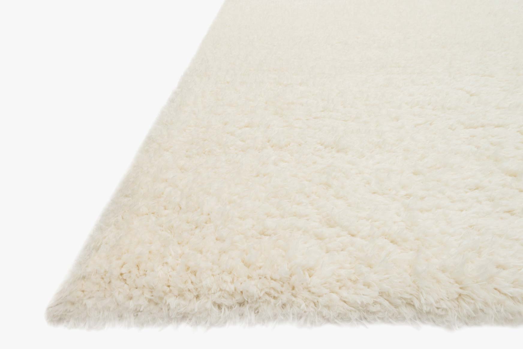 Ivory shag rug corner close-up showing thick, plush pile and fringe-free edge