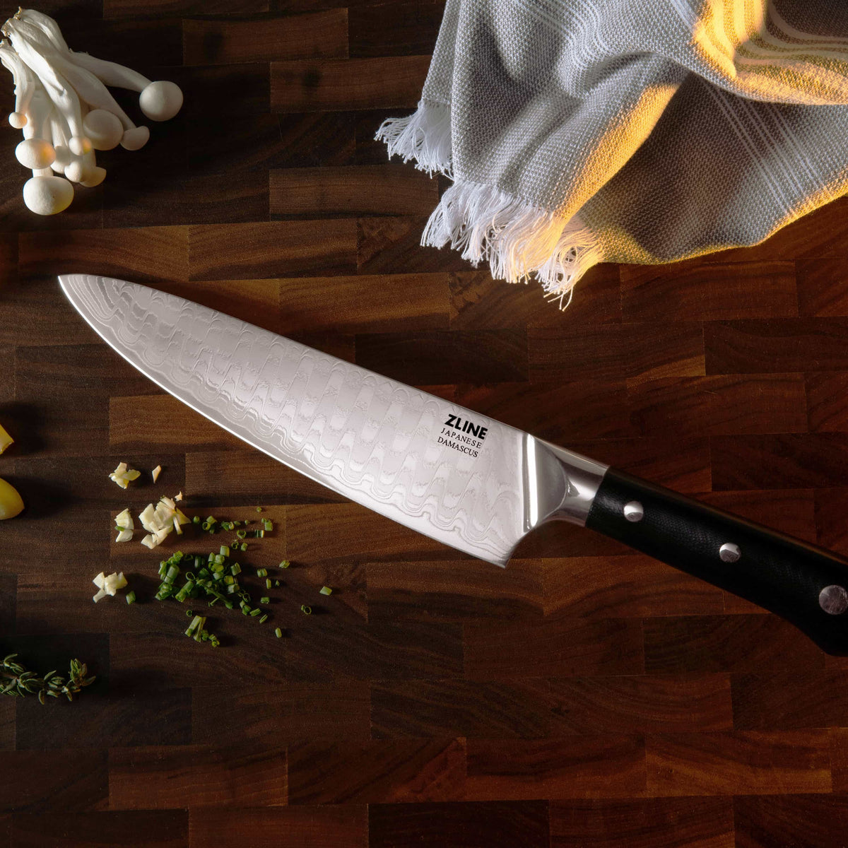Damascus steel chef’s knife on wooden board, black handle with rivets and patterned blade