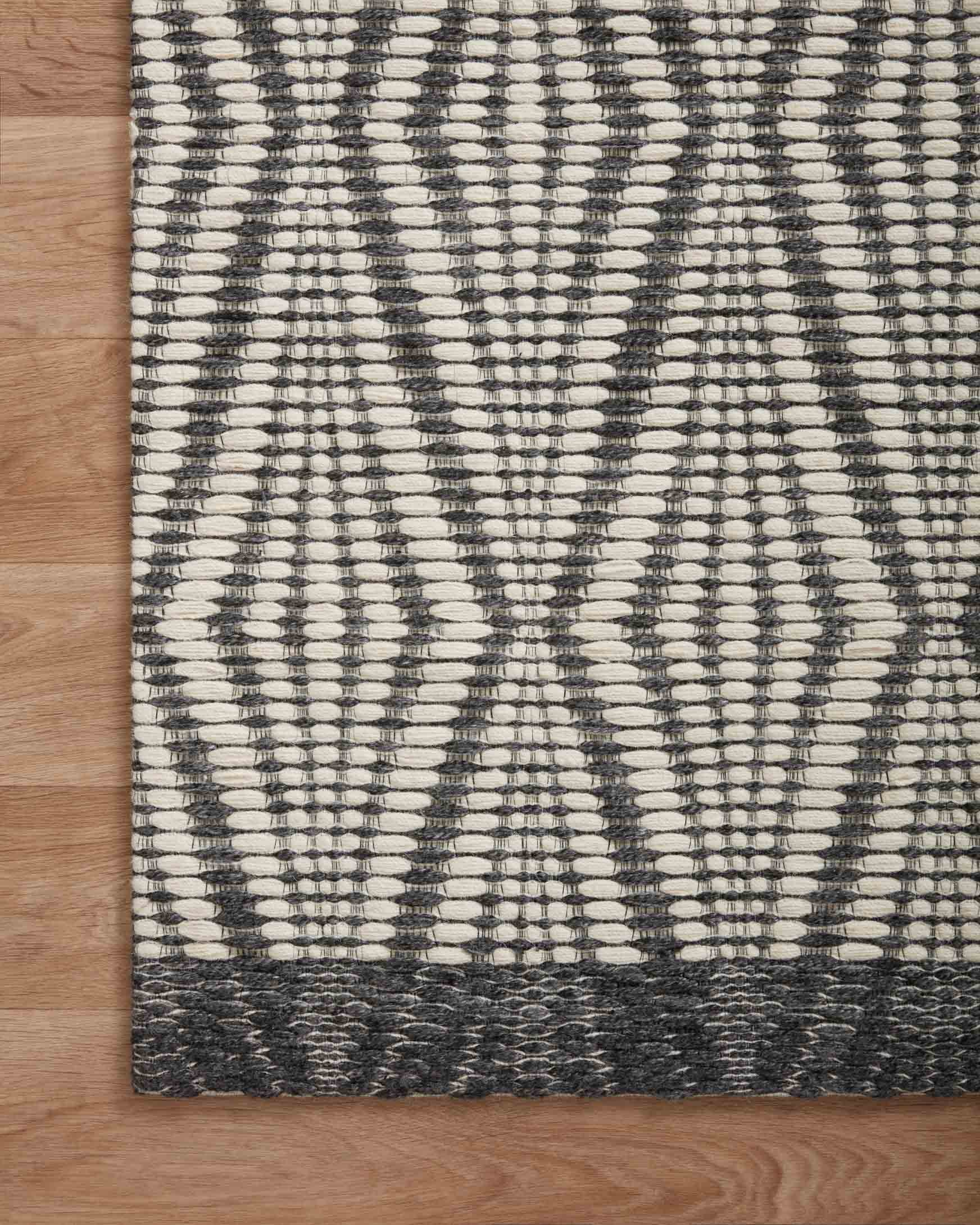 Ivory and charcoal diamond-pattern rug with flat weave texture and charcoal border