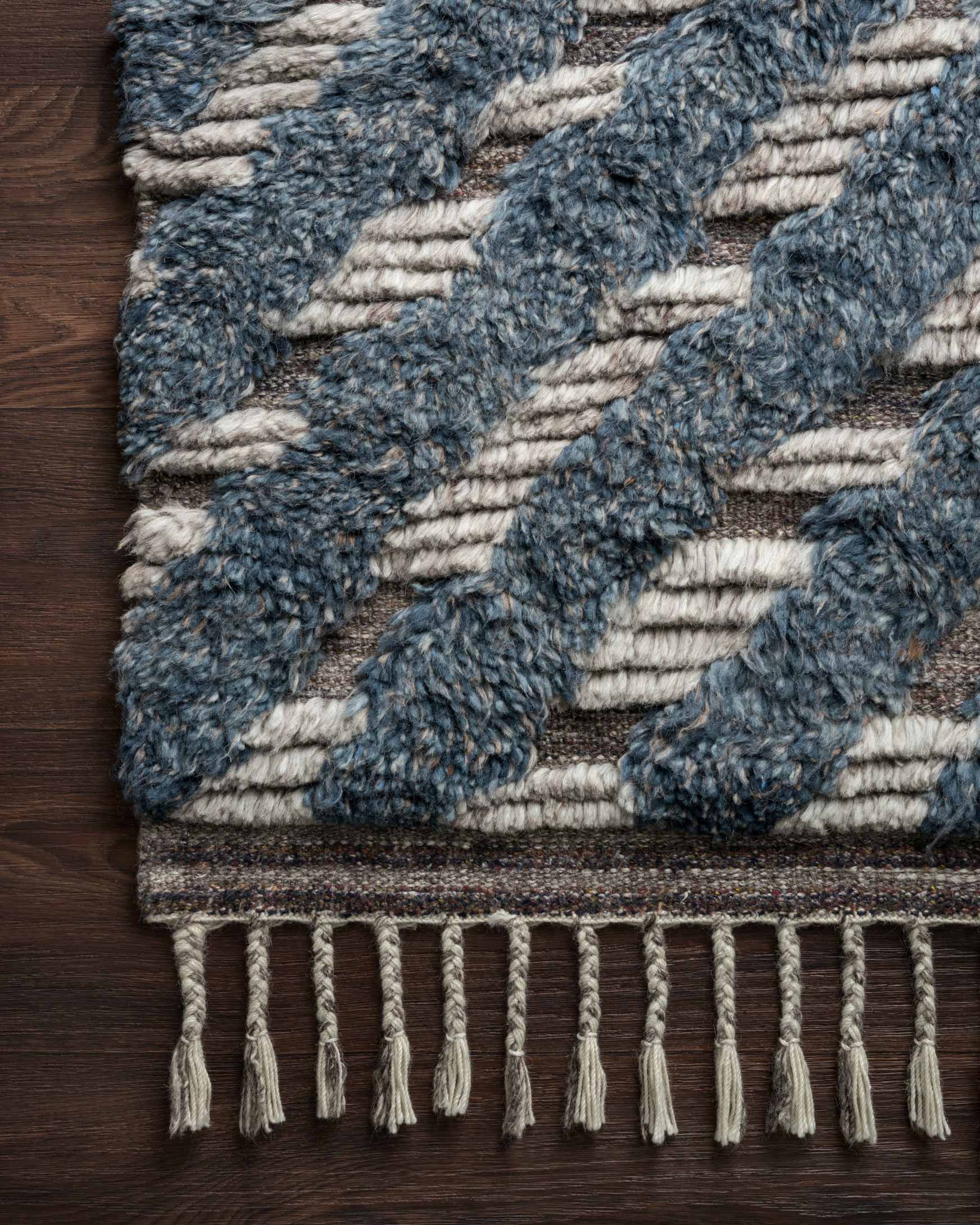Blue and pewter hand-knotted rug close-up, chunky texture with white fringe