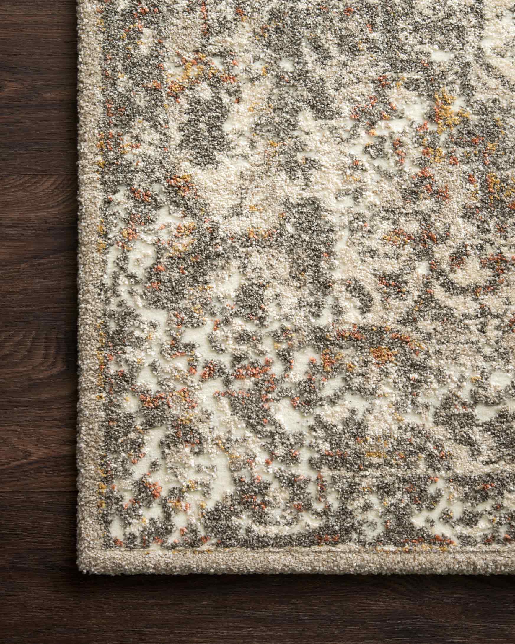 Power-loomed rug in sand and graphite, close-up of distressed motifs and flat woven edge