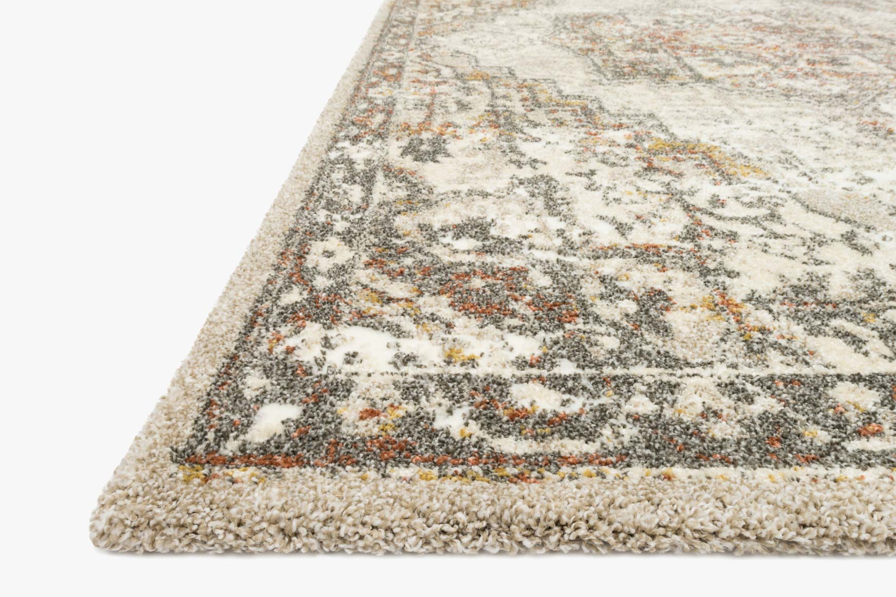 Power-loomed rug, sand and graphite, angled view with textured low-pile border