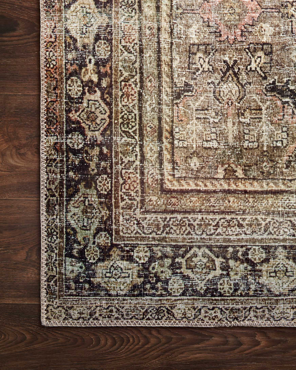 Close-up of traditional power-loomed rug texture with ornate motifs, olive and charcoal.