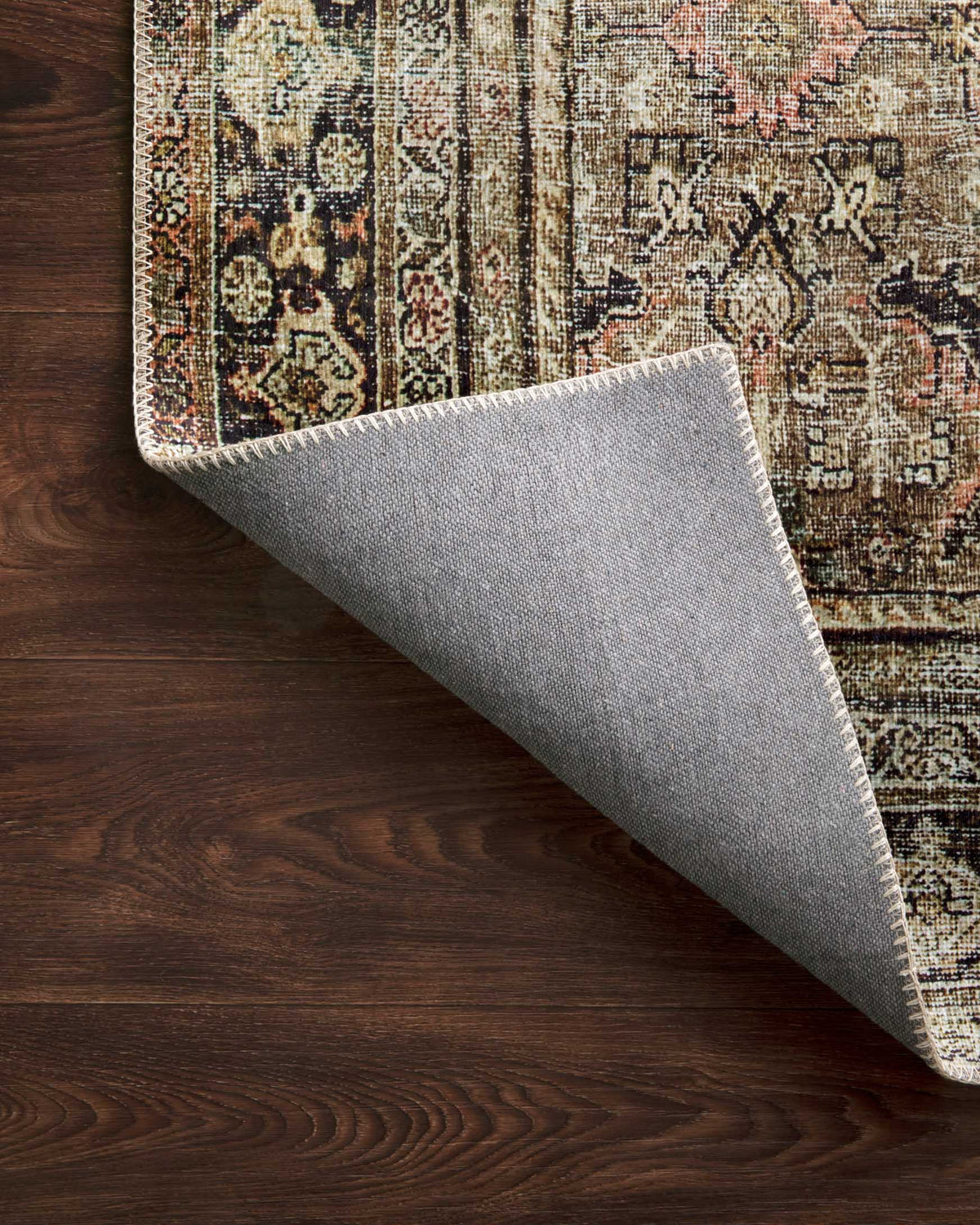 Traditional power-loomed rug corner with visible backing; olive and charcoal top pattern.