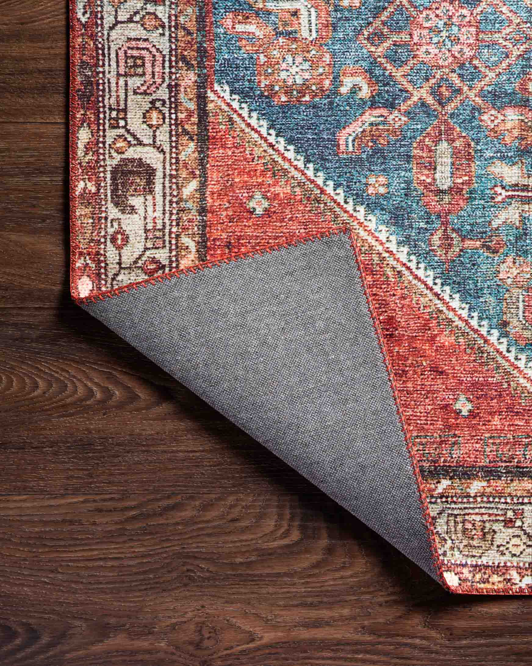 Traditional power-loomed rug close-up with marine blue and clay red underside backing