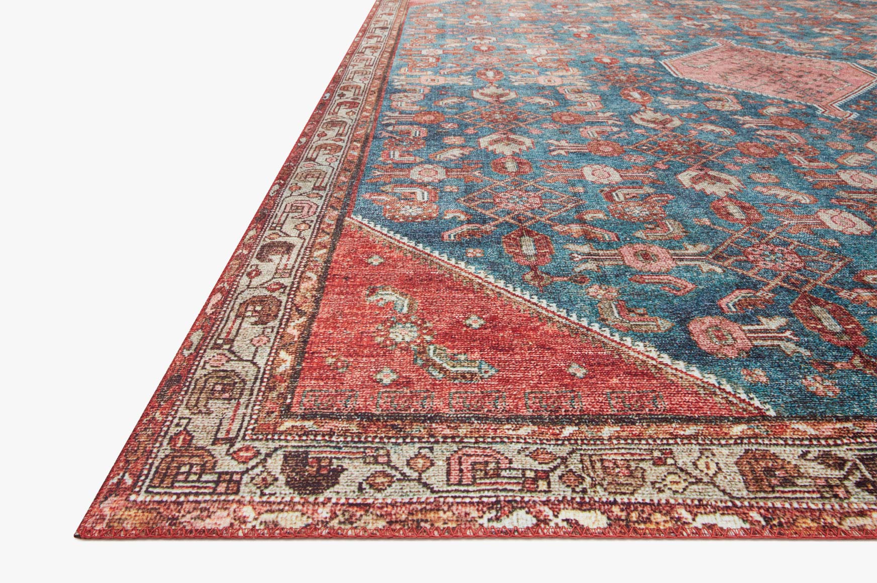 Traditional power-loomed rug corner view with marine blue and clay red border details