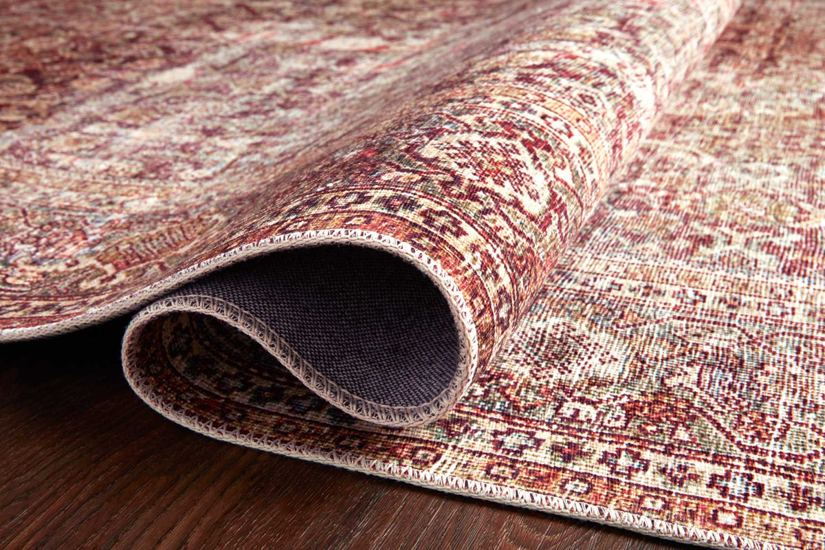 Rolled edge of traditional rug showing dark gray backing underside