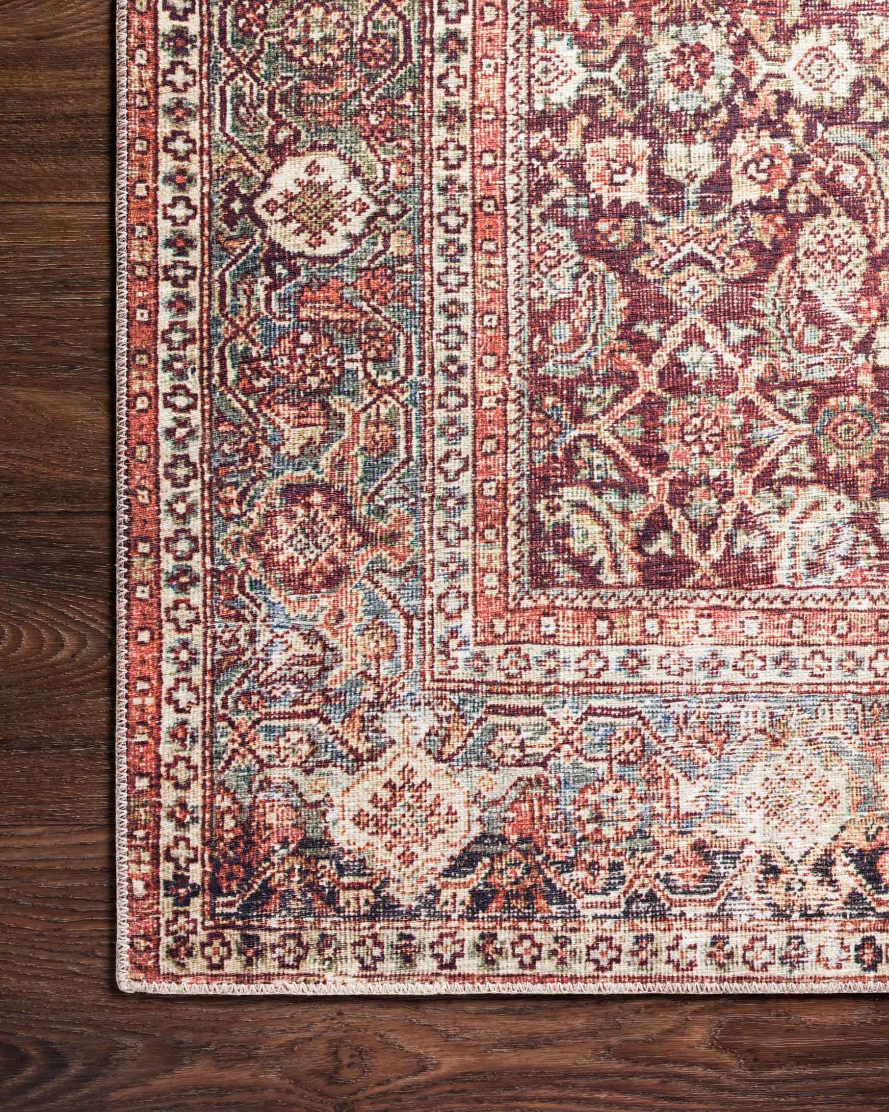Close-up of traditional rug border and center motifs in red, cream, and teal details