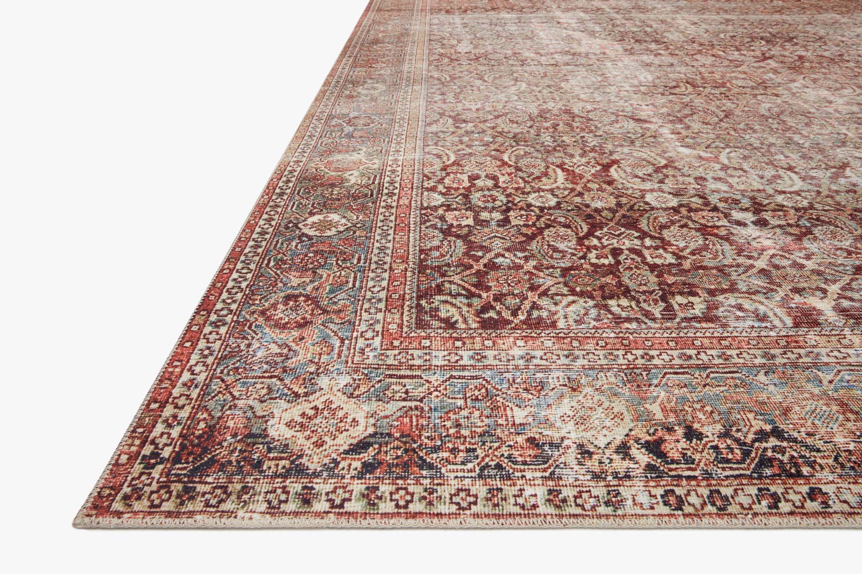 Corner view of traditional rug with red medallions, cream ground, and patterned border