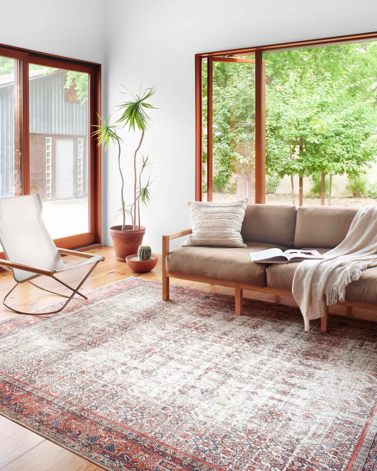 Ivory and brick traditional rug with distressed geometric pattern, laid flat.