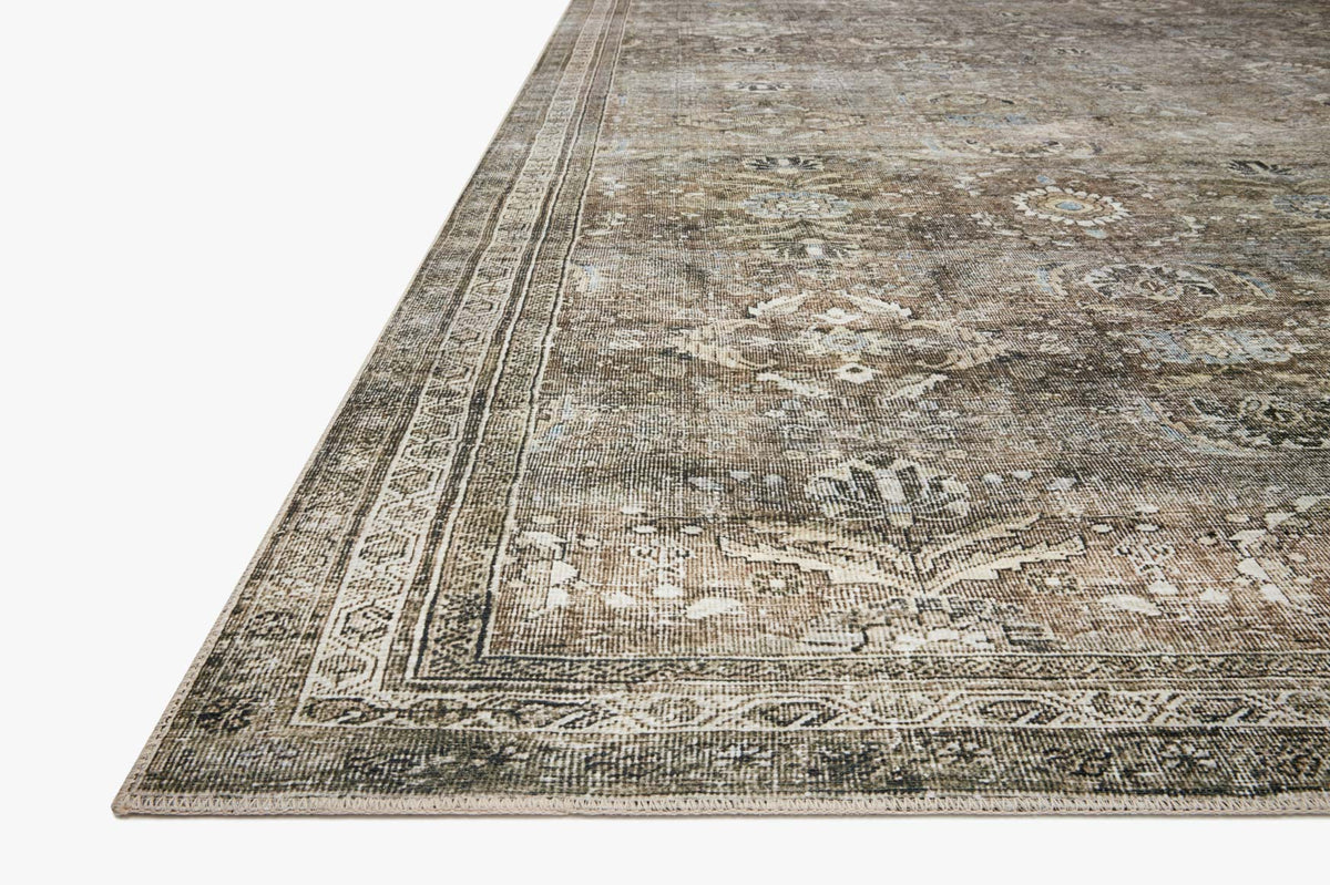 Corner view of antique grey rug with detailed pattern and stitched border.
