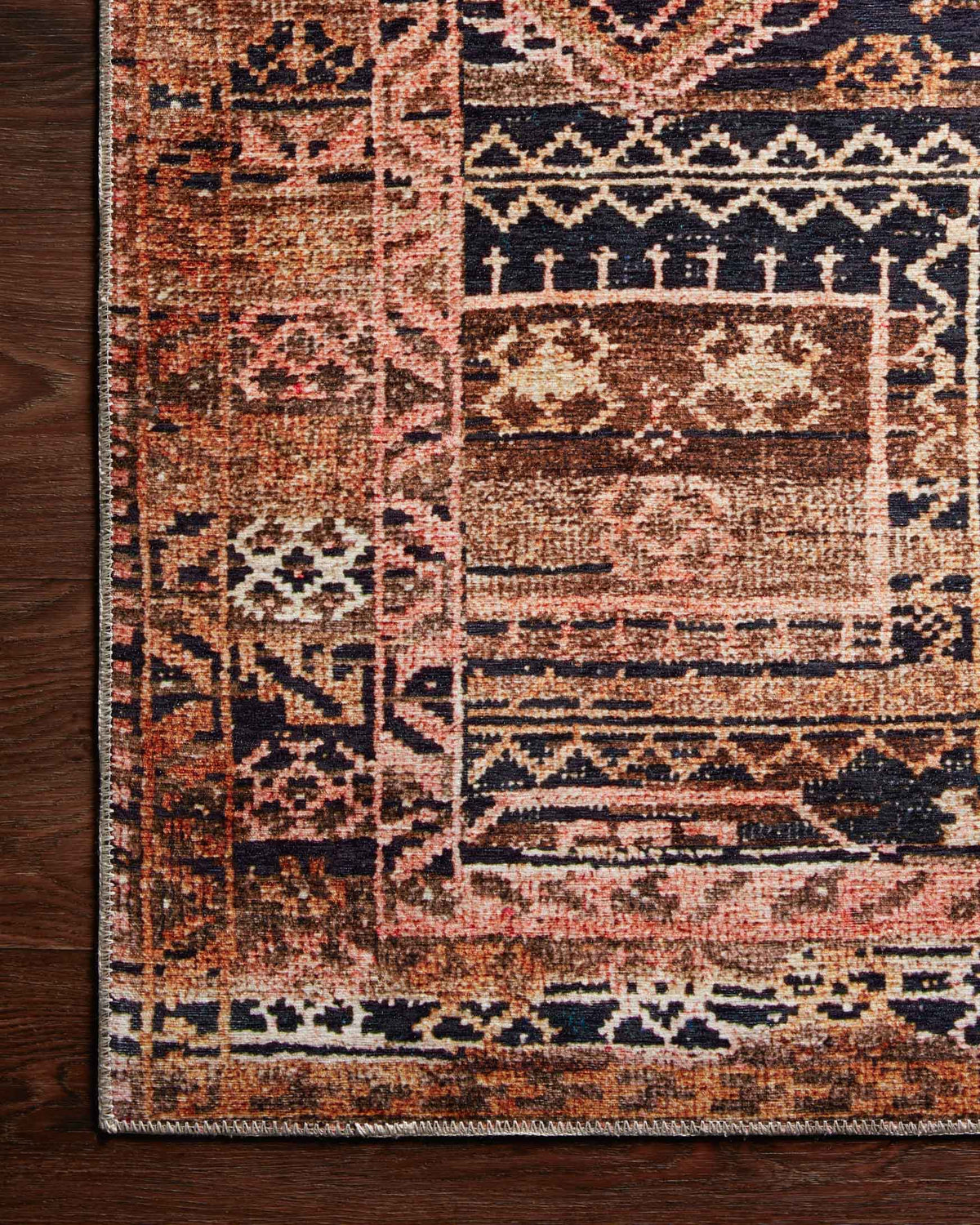 Traditional power-loomed rug corner with distressed geometric pattern and tightly woven texture.