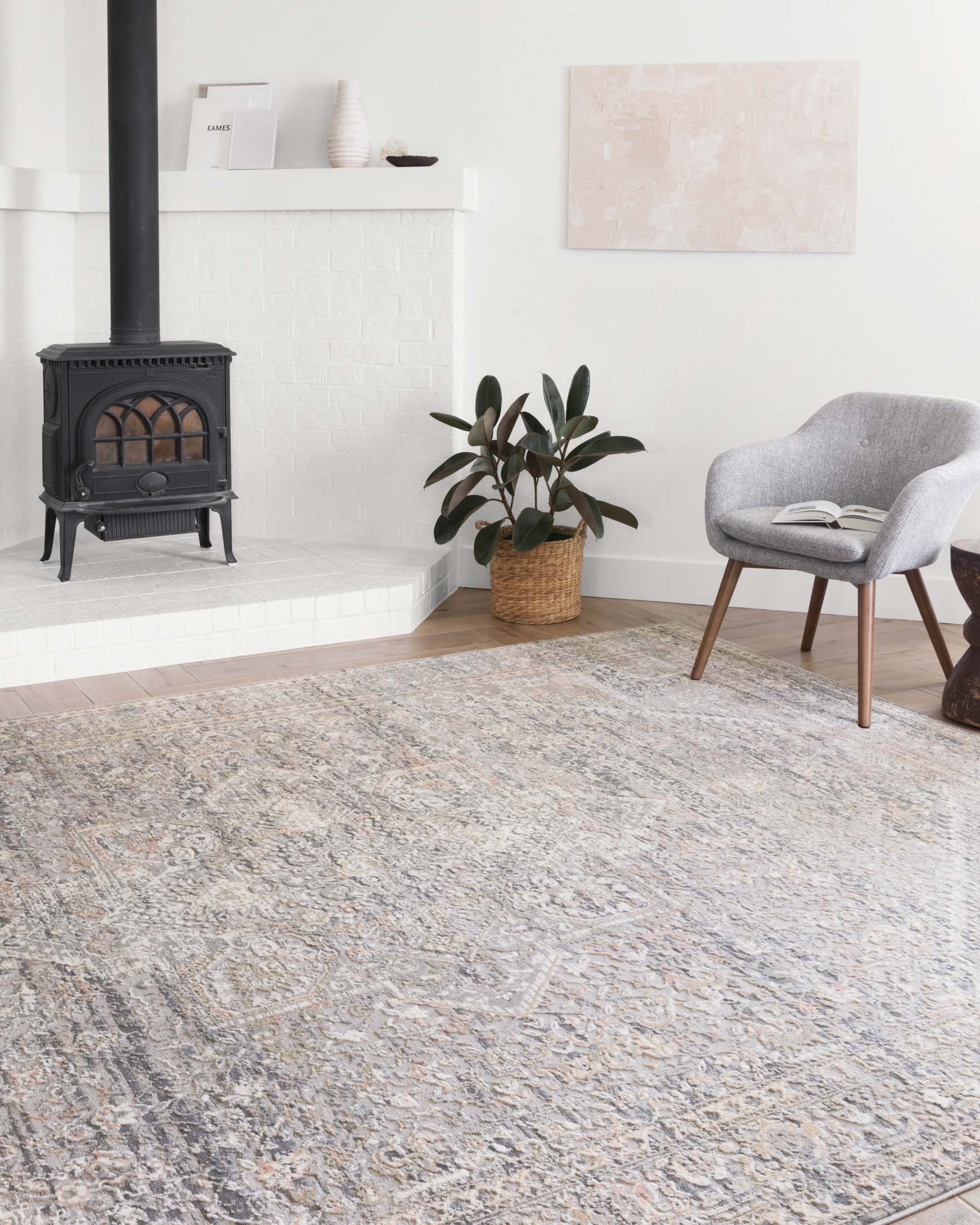 Light grey area rug with distressed ornate motifs, shown in a living room setting