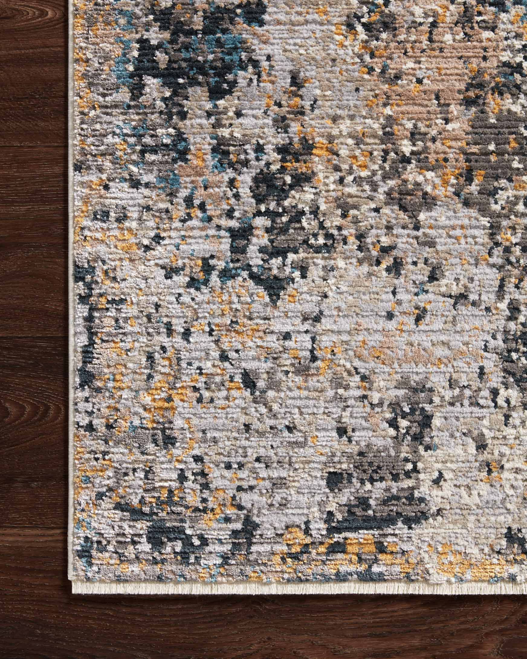 Transitional power loomed rug edge with textured silver, navy, and mustard abstract pattern