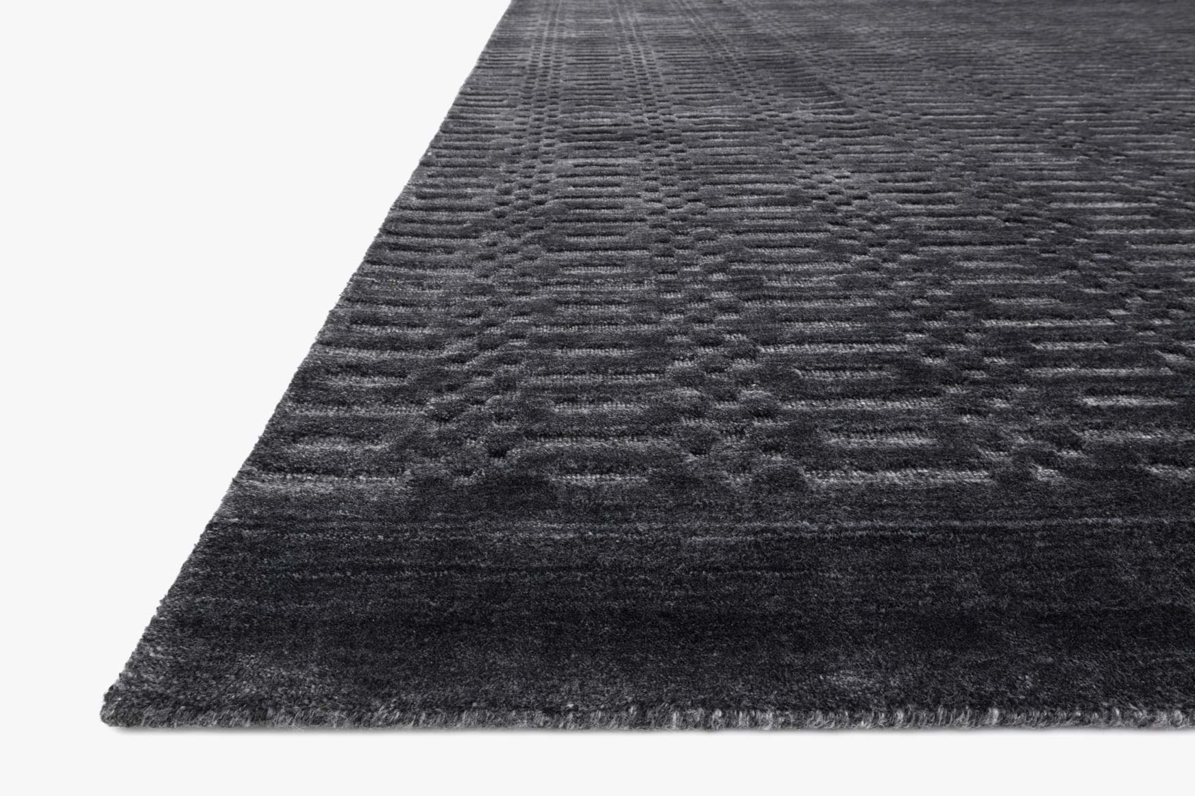 Charcoal hand-loomed rug corner detail with low-pile texture and border