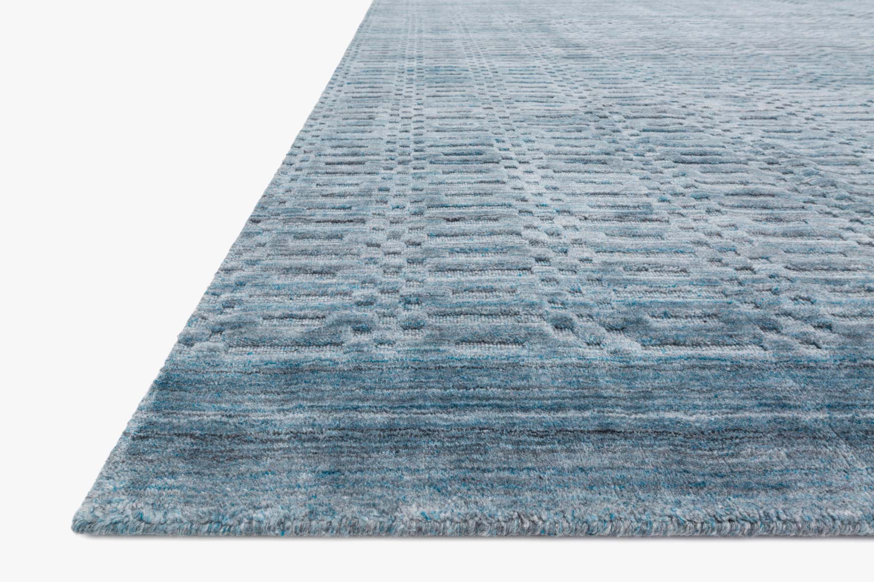 Ocean blue textured rug corner view with geometric pattern across flat weave.
