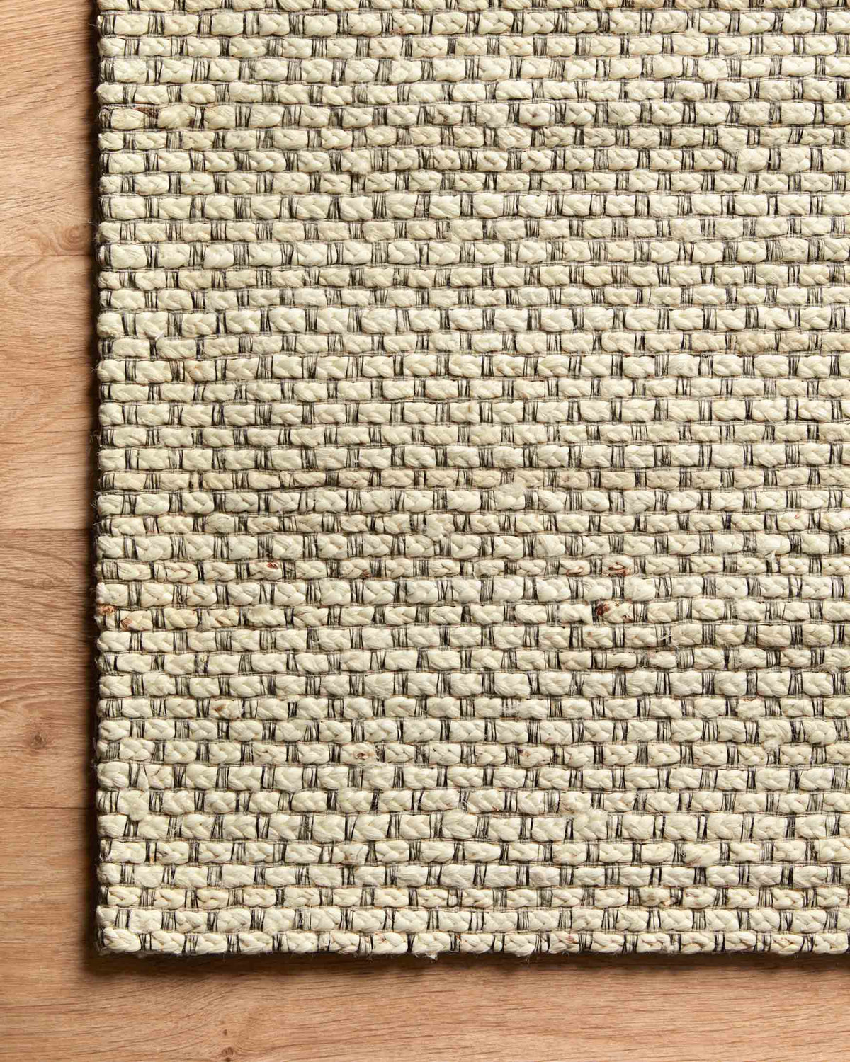 Ivory hand-woven rug with visible border edge and tight loop-texture weave.