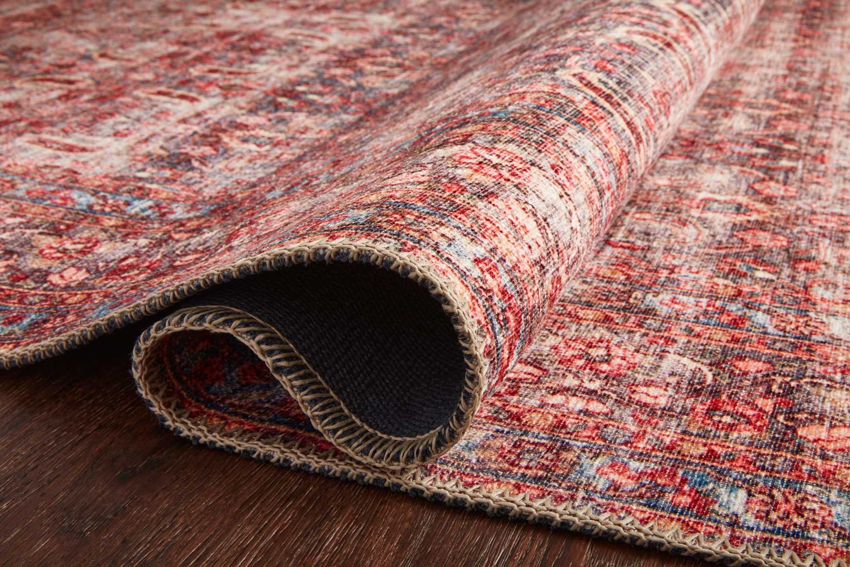 Rolled-up traditional rug showing textured weave and fringe trim on the edge