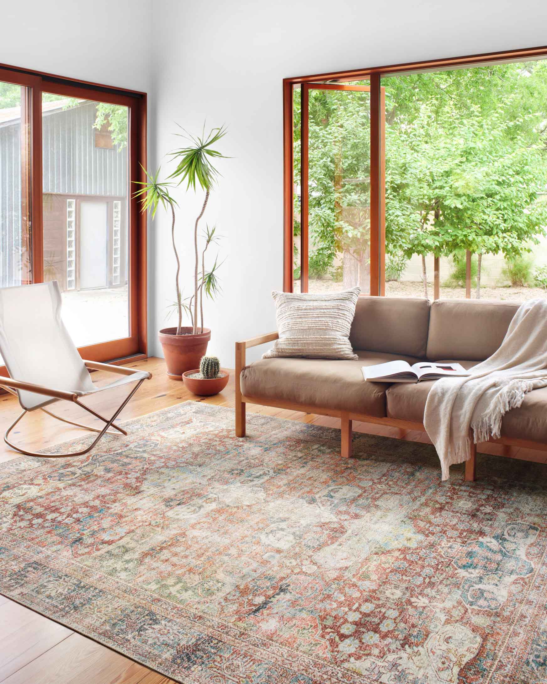 Traditional area rug laid in living room, showing intricate brick, blue, and cream pattern.