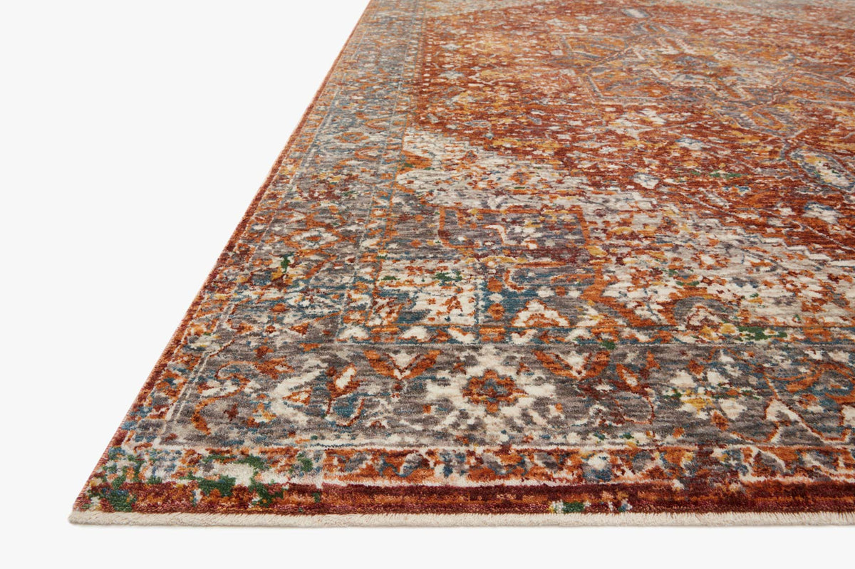 Corner view of rust and cream traditional rug with distressed multicolor geometric motifs