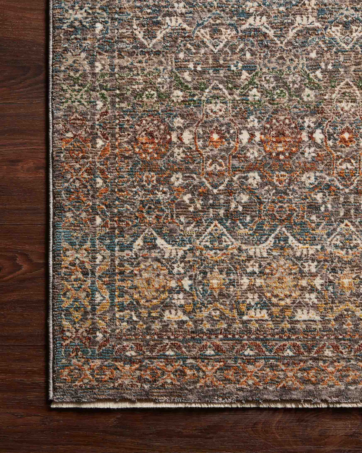 Close-up of traditional rug border with distressed geometric pattern in stone, blue, orange