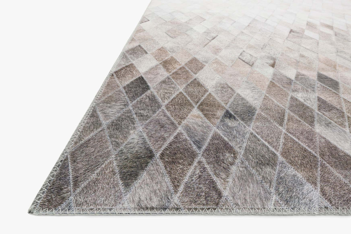 Edge view of sand and taupe rug featuring stacked diamond motif