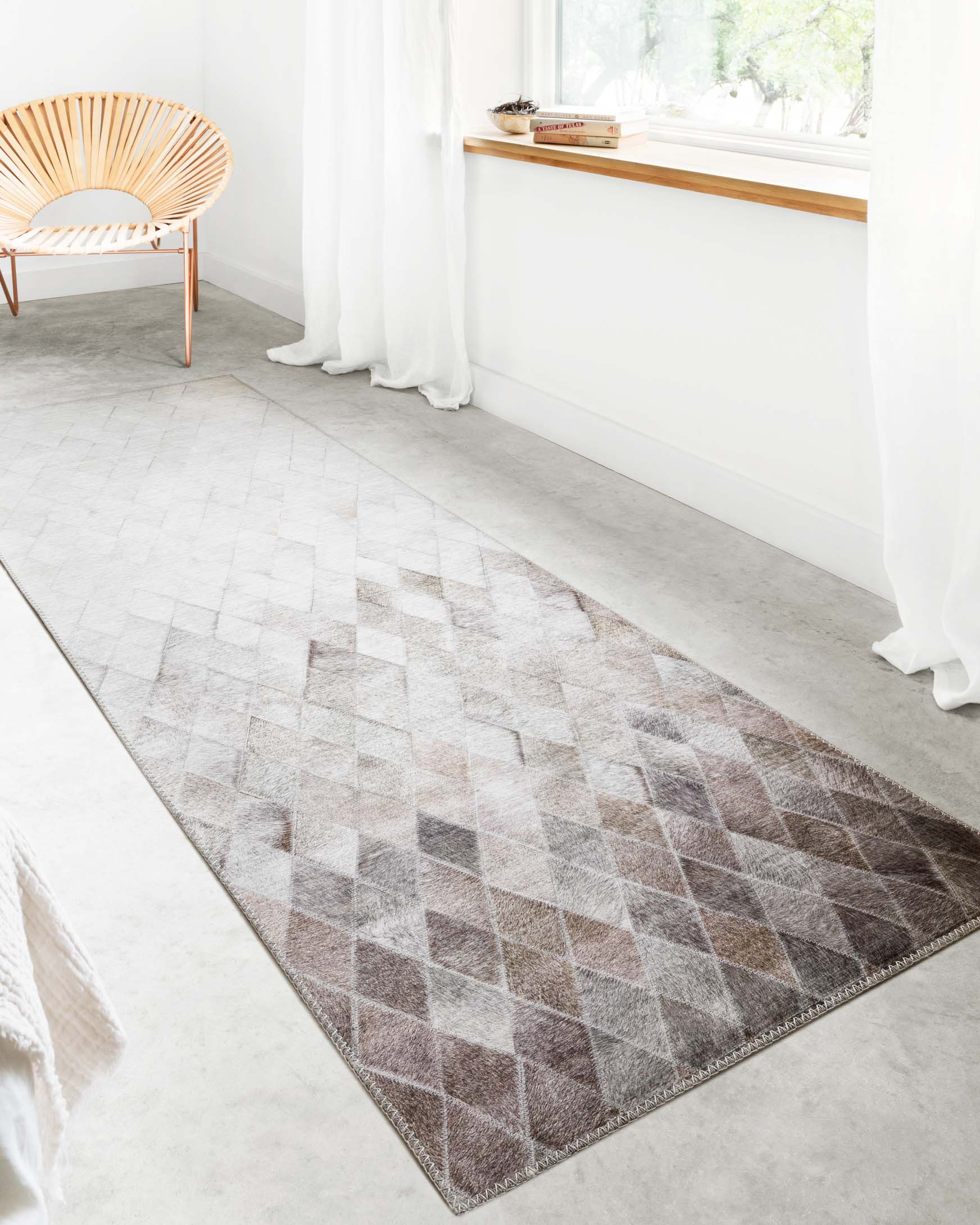 Sand and taupe rug with repeating diamond pattern, diagonal corner view