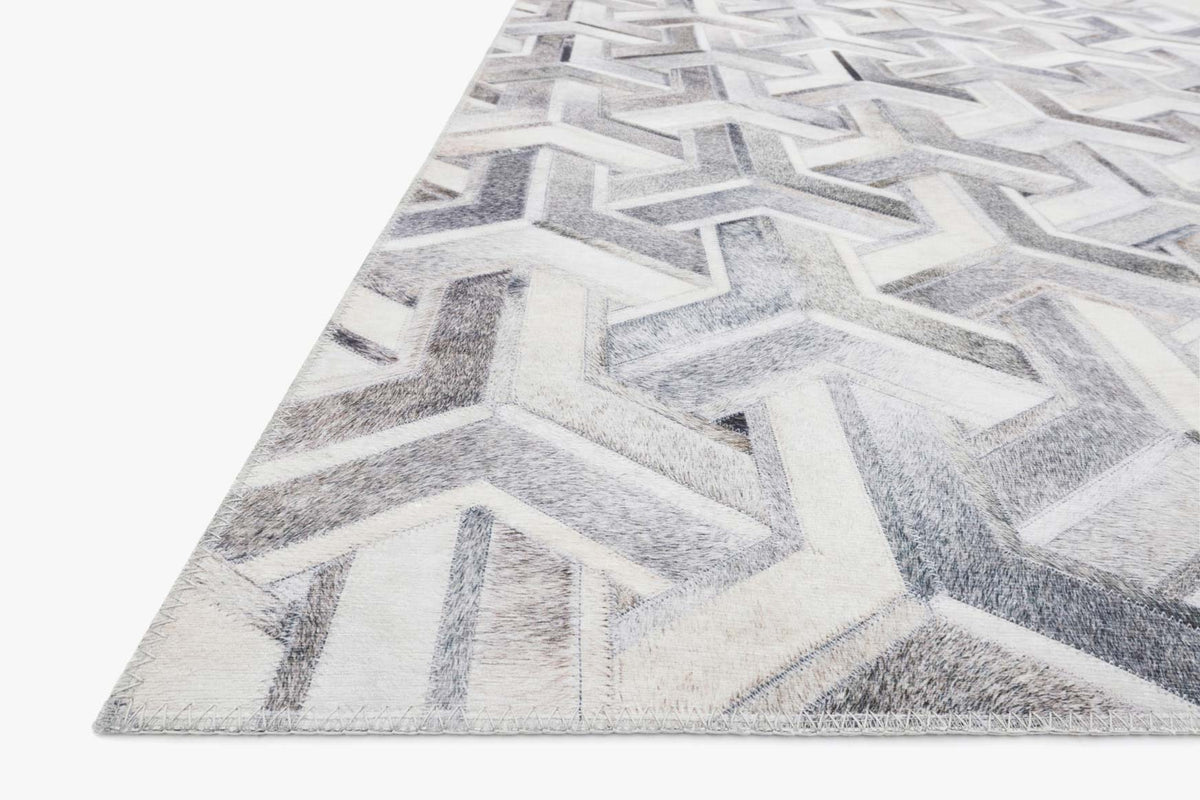 Triangle corner view of silver and ivory geometric rug with distressed zigzag lines