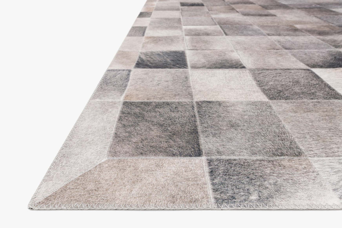 Close-up corner view of charcoal and grey square-block rug pile