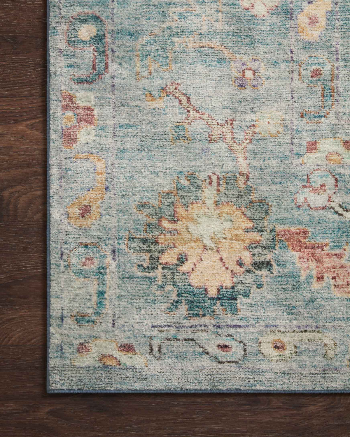 Close-up of denim blue rug texture with faded multicolor floral motifs