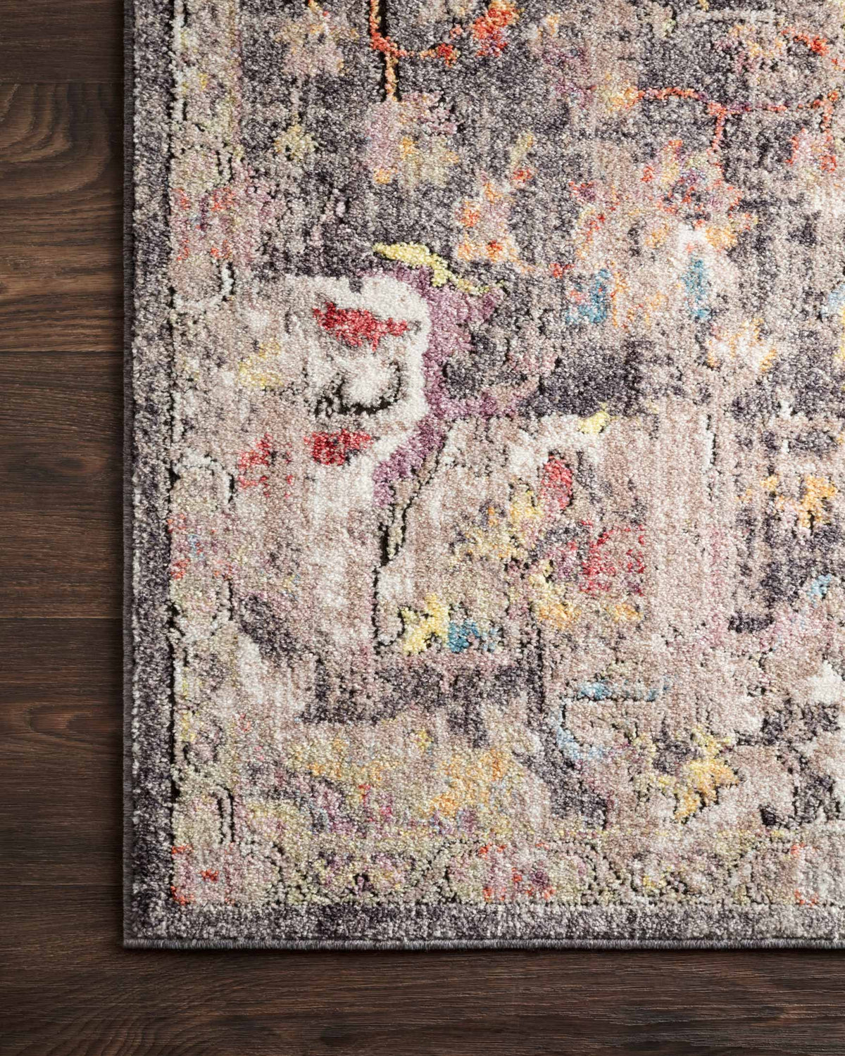 Charcoal rug close-up with multicolor distressed abstract medallion pattern and fringeless edge