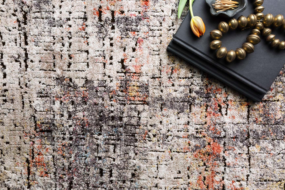 Close-up of graphite gray rug with distressed abstract blocks and orange accents