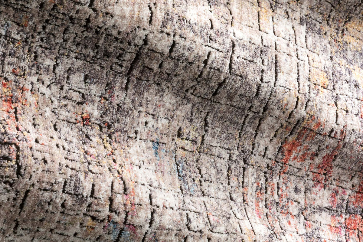 Close-up rug texture with distressed gray pattern and hints of orange and white