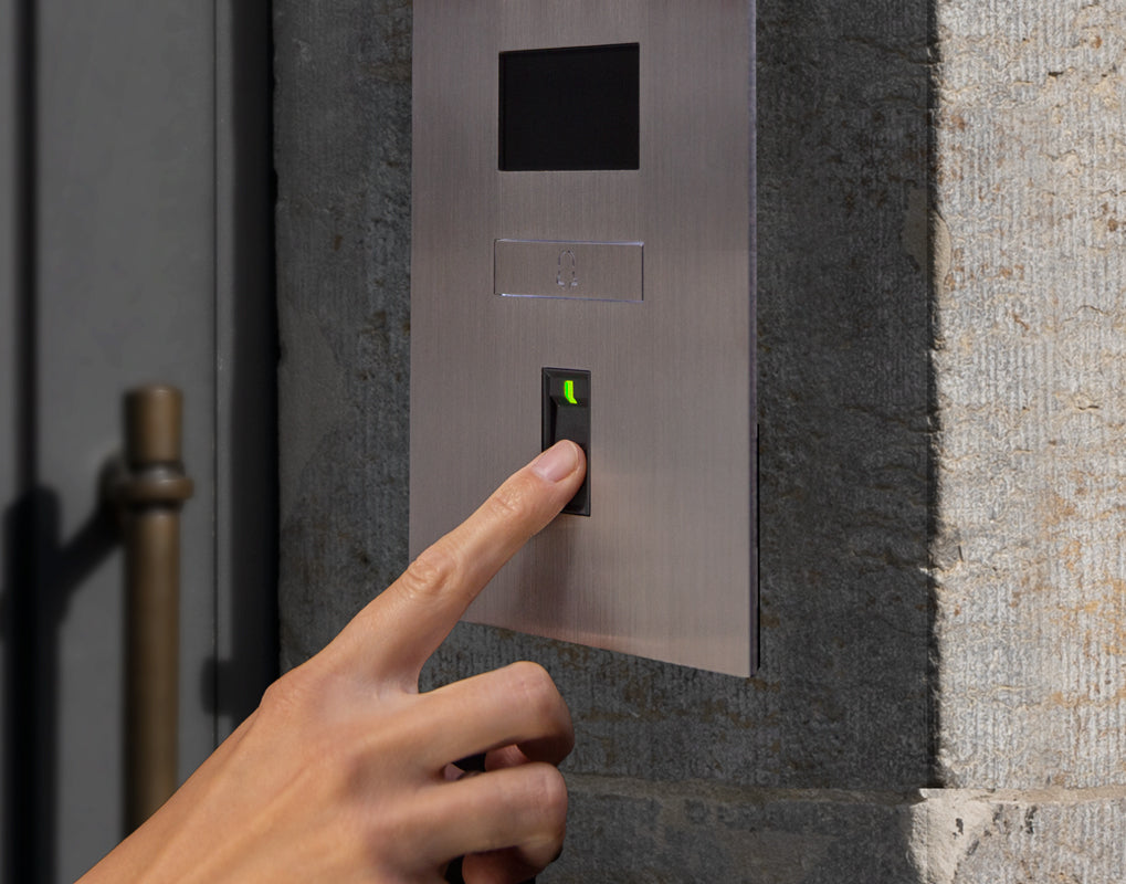 Finger pressing fingerprint reader on stainless steel video door intercom panel