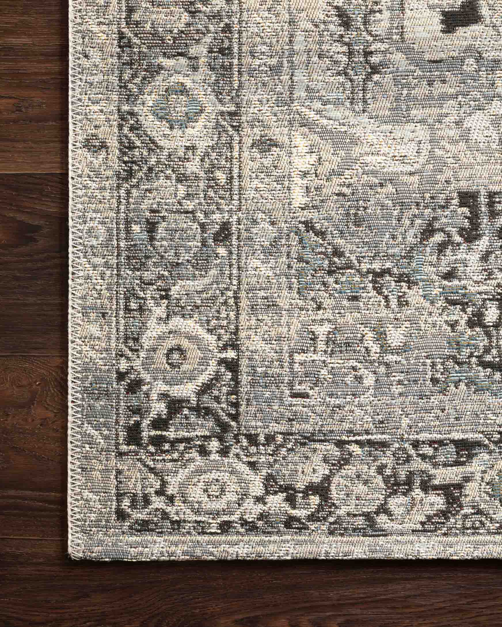 Grey and blue rug close-up of geometric motifs on textured surface