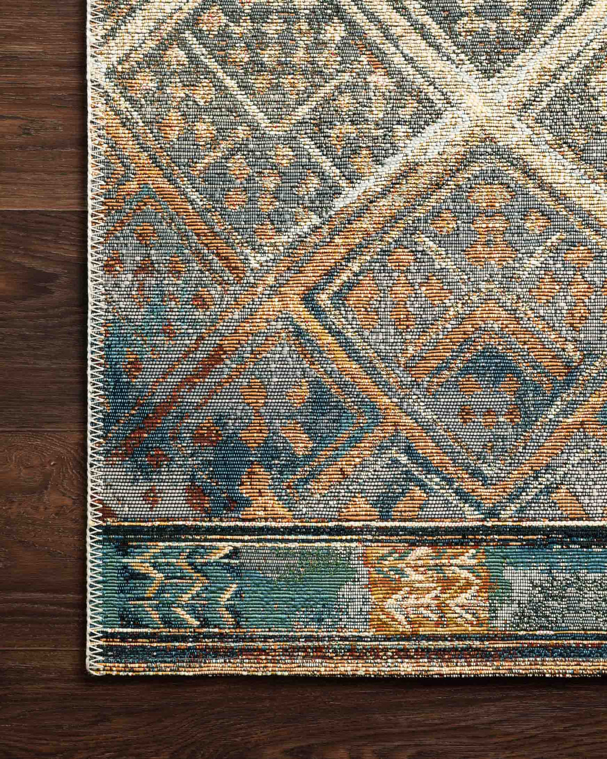 Indoor/outdoor power-loomed rug corner detail, ivory geometric lattice with blue and orange