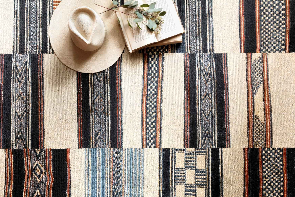 Ivory geometric rug detail with vertical stripes and blue, navy, orange accents