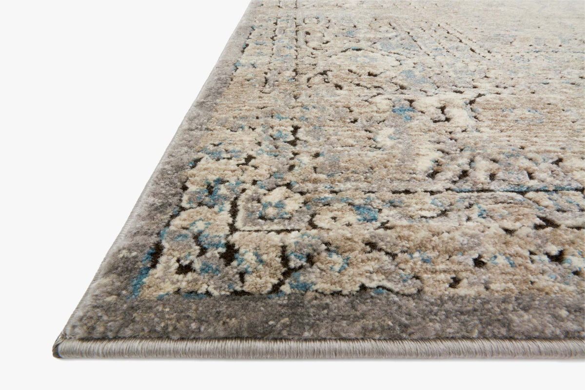Corner close-up of transitional rug, grey/stone with blue and teal speckled pattern