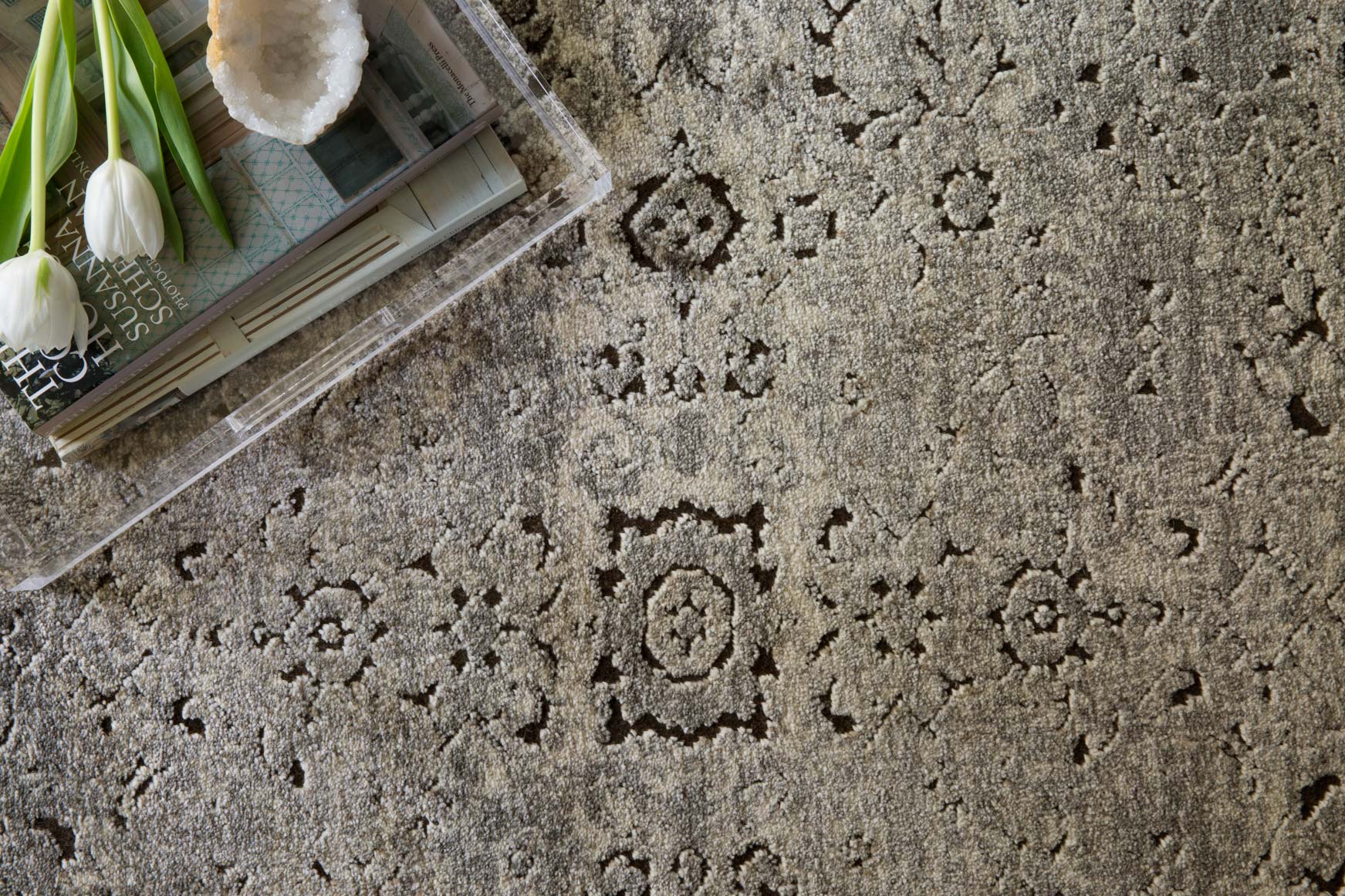 Close-up of grey and charcoal rug showing distressed texture and repeating geometric motifs
