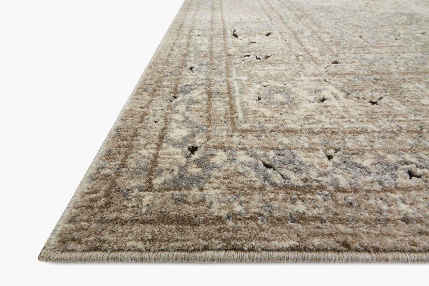 Sand and ivory rug corner detail with distressed pattern and low flat pile edge