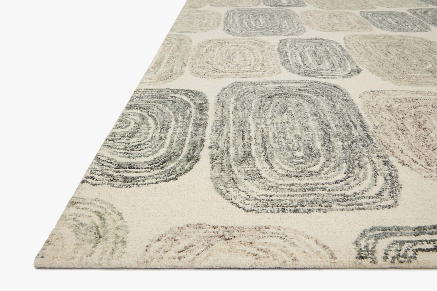 Hand-tufted rug corner with abstract swirl blocks in dark gray on light neutral ground