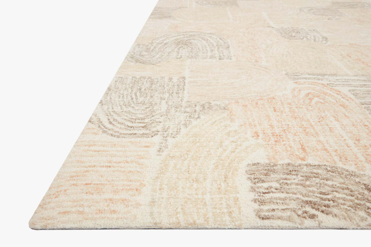 Abstract hand-tufted area rug corner in light cream with peach and tan swirl pattern