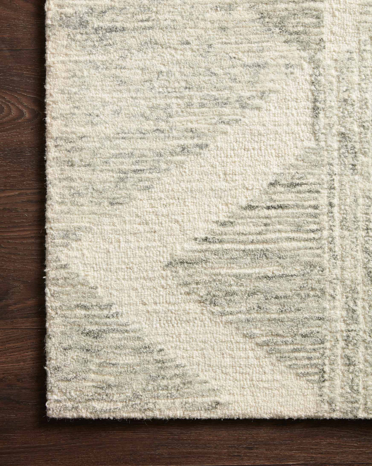 Light gray rug close-up with textured short pile and subtle geometric detailing