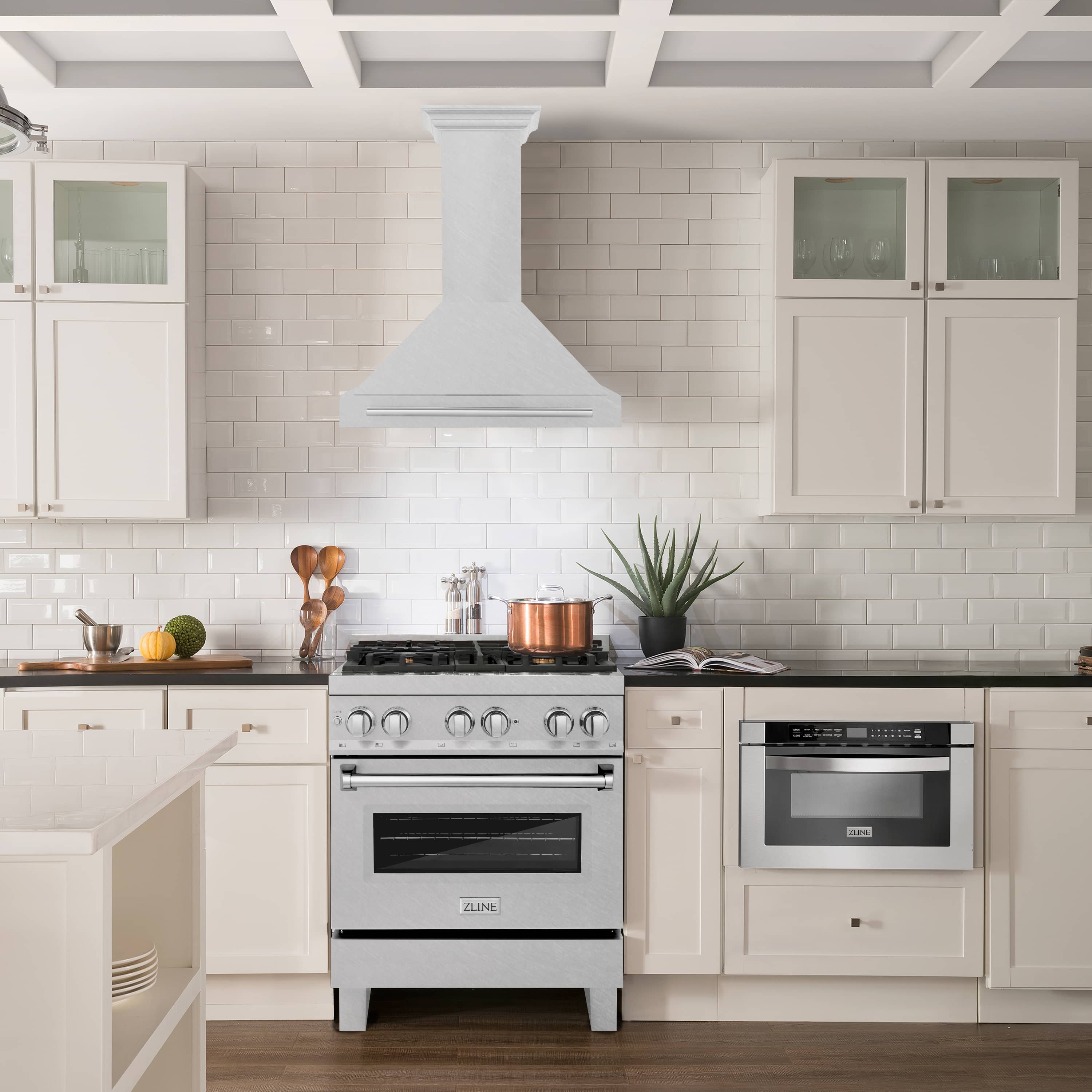 Wall-mounted satin stainless range hood above a freestanding gas range