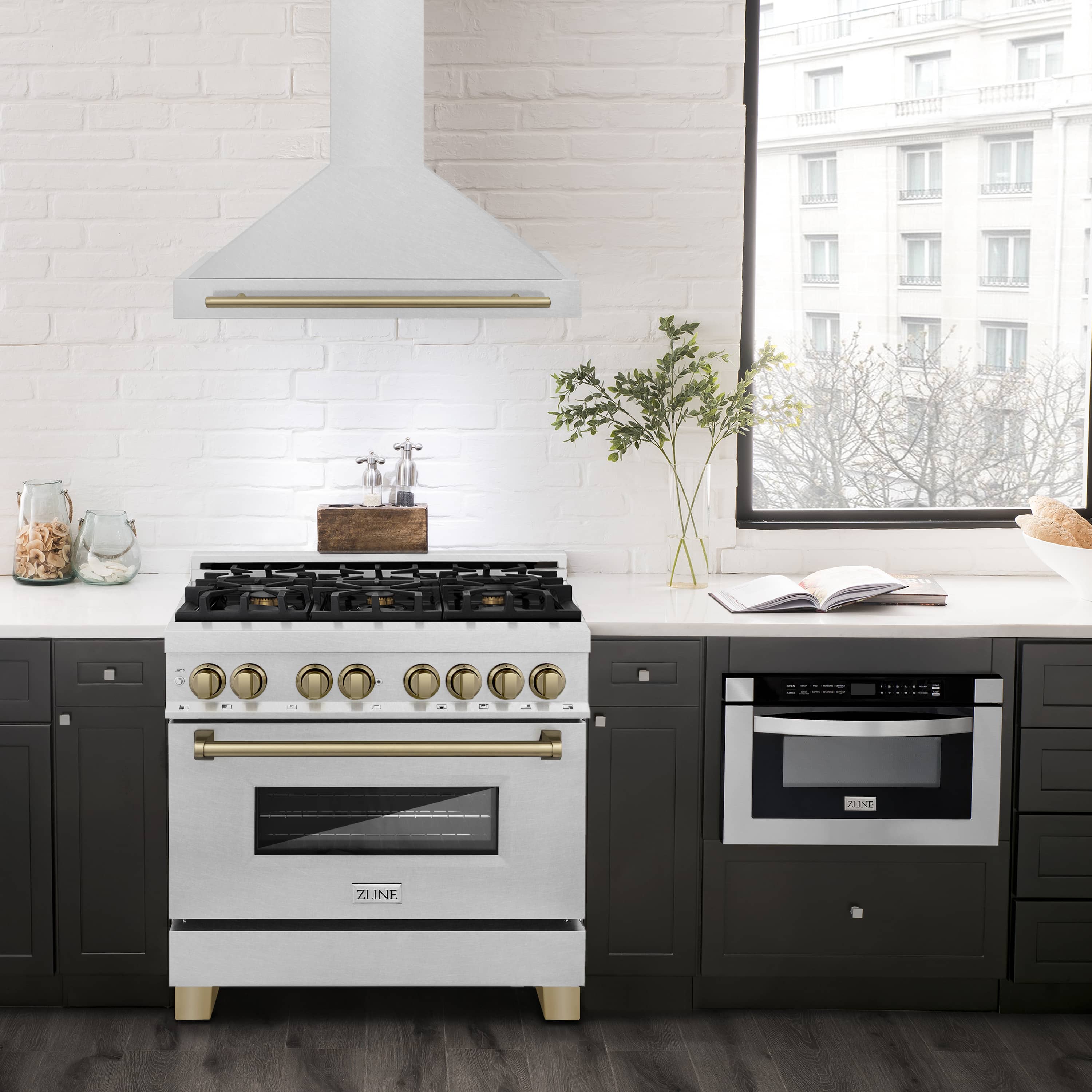 Wall-mounted chimney range hood in satin stainless steel with champagne bronze trim bar.